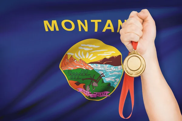 Medaille in der hand mit Flagge auf Hintergrund - Bundesstaat Montana. Teil einer Serie. — Stockfoto