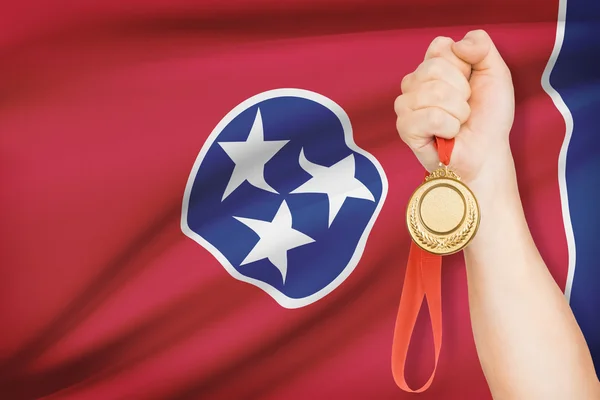 Medal in hand with flag on background - State of Tennessee. Part of a series. — Stock Photo, Image