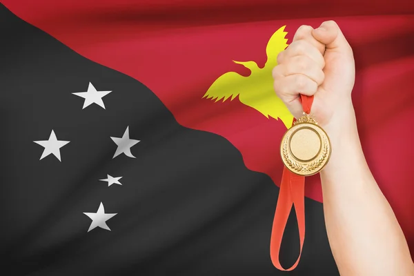 Medal in hand with flag on background - Independent State of Papua New Guinea — Stock Photo, Image