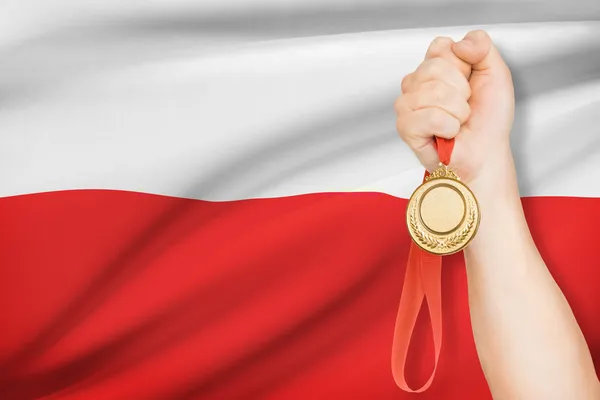 Medaglia in mano con bandiera sullo sfondo - Polonia — Foto Stock