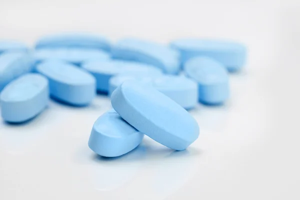 Bunch of blue pills on grey table — Stock Photo, Image