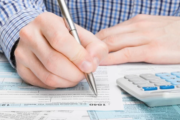 Stany Zjednoczone podatku formularza 1040 - mężczyzna, wypełniając formularz podatkowy — Zdjęcie stockowe