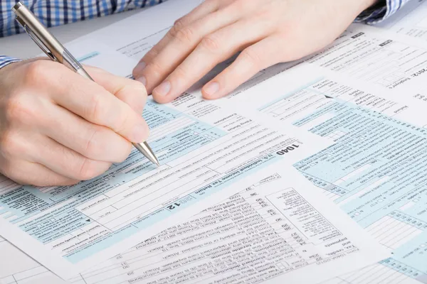 Nos forma - hombre rellenando el formulario de impuestos de impuestos 1040 — Foto de Stock