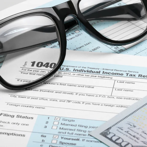 Formulário de imposto Estados Unidos 1040 com dólares e óculos - proporção de 1 para 1 — Fotografia de Stock