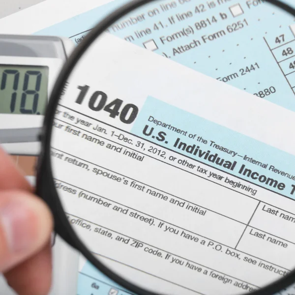美国税收形式 1040年拿放大镜-1 对 1 的比例 — 图库照片