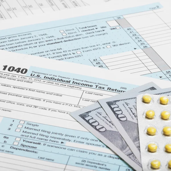 United States of America Tax Form 1040 with dollars and pills - 1 to 1 ratio — Stock Photo, Image