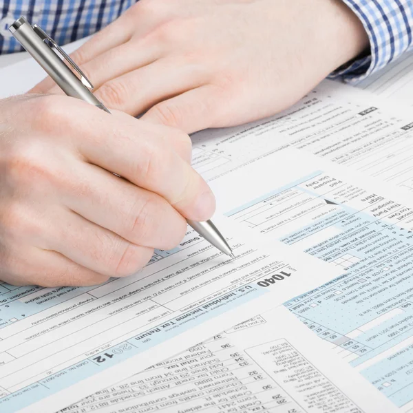 United States of America Tax Form 1040 - man performing tax calculation - 1 to 1 ratio — Stock Photo, Image