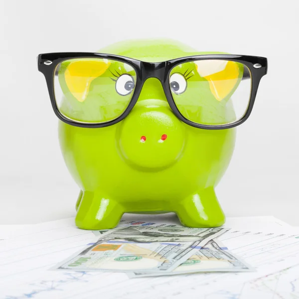 Green piggy bank over stock market chart with 100 dollars banknote - 1 to 1 ratio — Stock Photo, Image