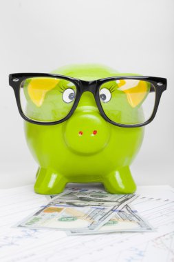 hisse senedi grafiği ile 100 dolarlık banknot üzerinde kumbara