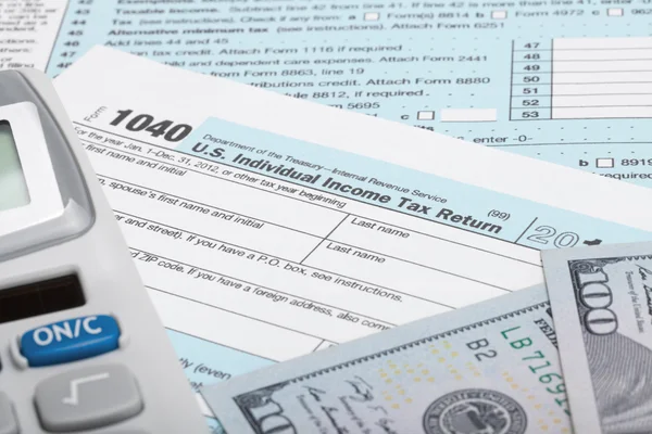 Ons belasting formulier 1040 met Rekenmachine en 100 Amerikaanse dollarbiljetten — Stockfoto