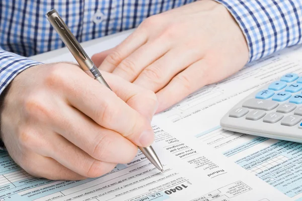 Male filling out 1040 United States of America Tax Form - studio shot — Stock Photo, Image