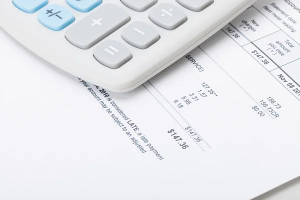 Calculator over utility bill — Stock Photo, Image