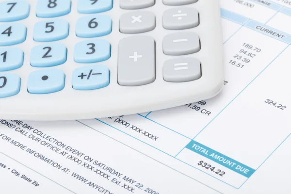 Calculator over utility bill - studio shot — Stock Photo, Image