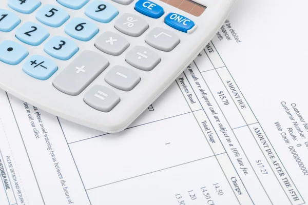 Studio shot of receipt next to calculator — Stock Photo, Image