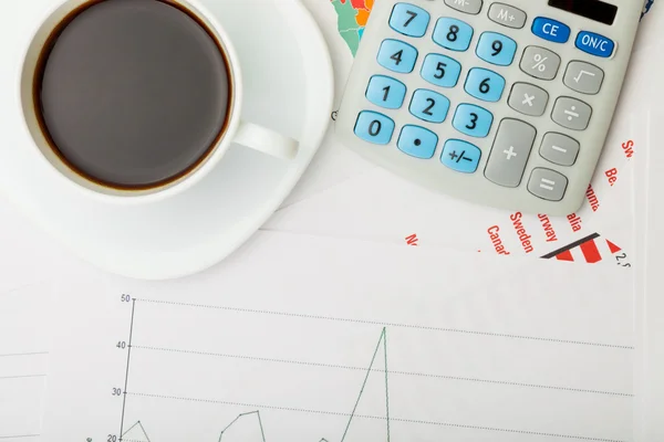 Coffee cup over financial documents — Stock Photo, Image