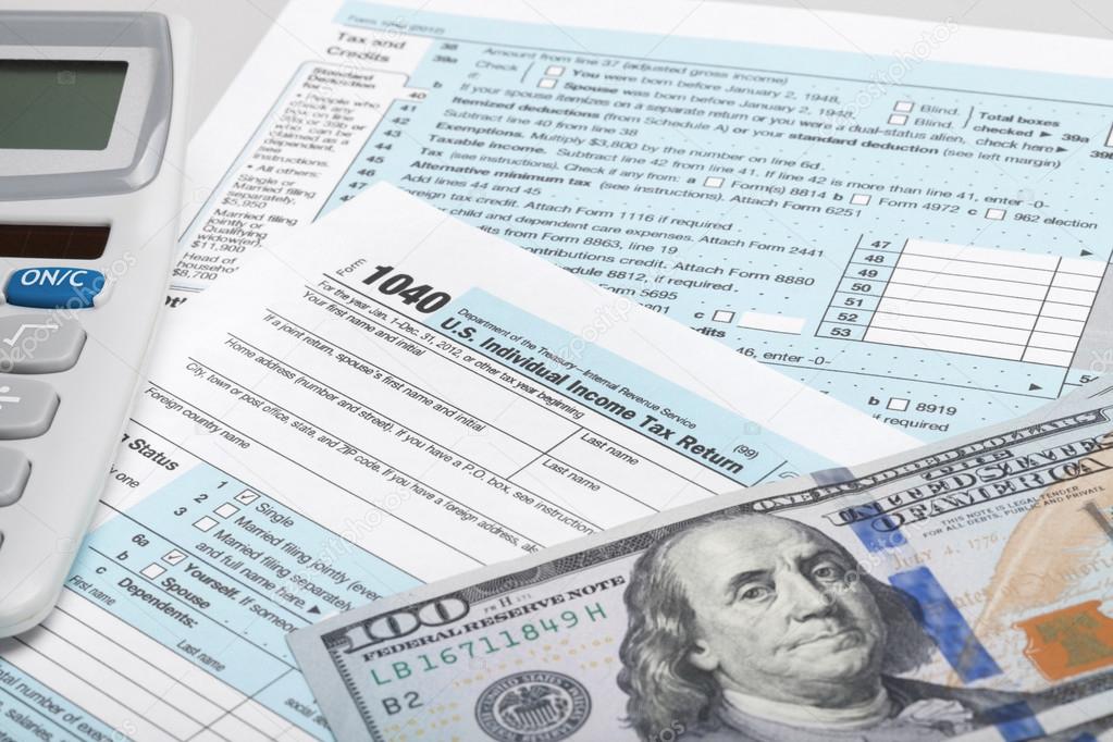 USA Tax Form 1040 with calculator and 100 US dollar bills