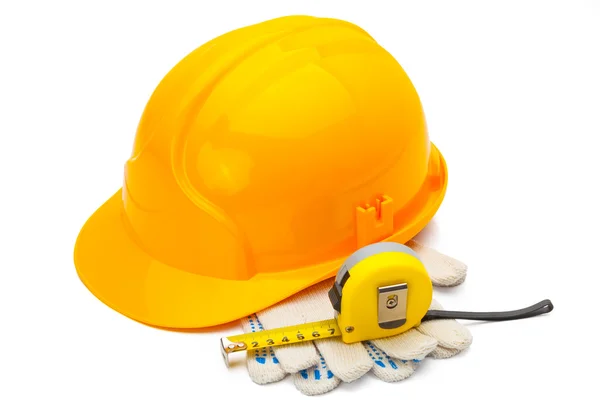 Casque de construction avec ruban à mesurer et gants sur fond blanc — Photo