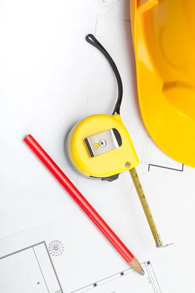 청사진 위에 연필 및 측정 테이프를 가진 노란 건설 헬멧 — 스톡 사진