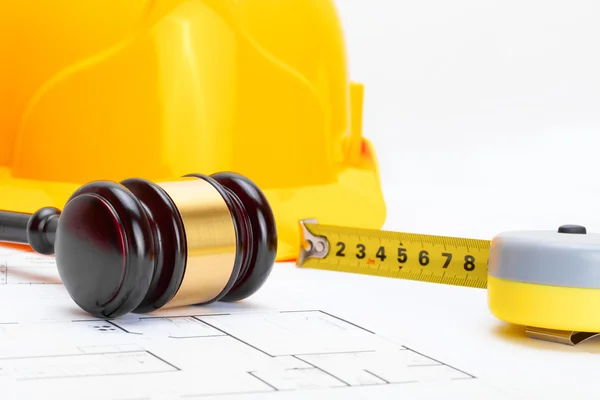 Wooden judge gavel with measure tape and protective helmet - studio shoot