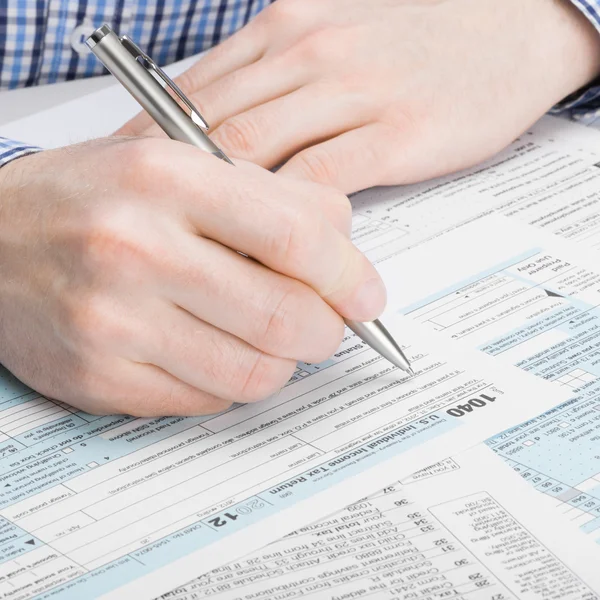 United States of America Tax Form 1040 - man performing tax calculations - 1 to 1 ratio — Stock Photo, Image