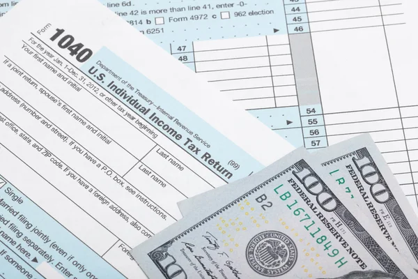 USA 1040 Tax Form with two 100 US dollar banknotes over it - studio shoot — Stock Photo, Image