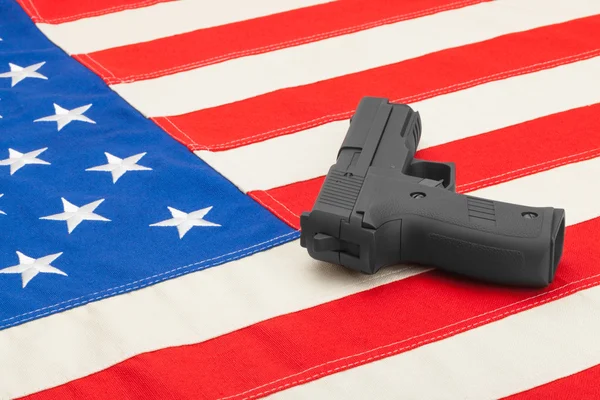 Gun laying over USA flag - studio shoot — Stock Photo, Image