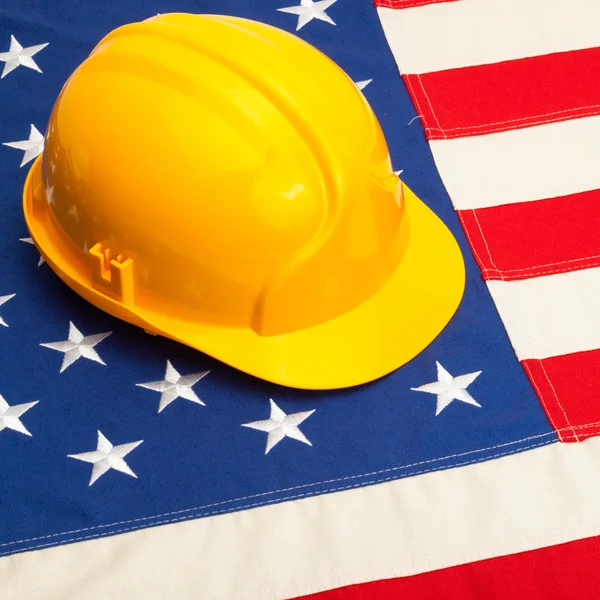 Construction helmet laying over USA flag - studio shoot - 1 to 1 ratio — Stock Photo, Image