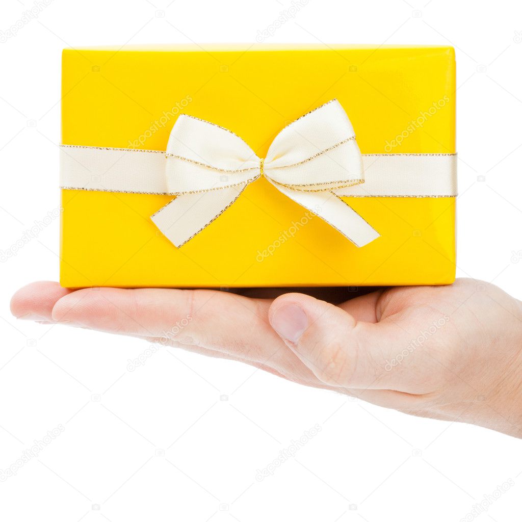 Yellow gift box with golden edge ribbon on male palm - 1 to 1 ratio