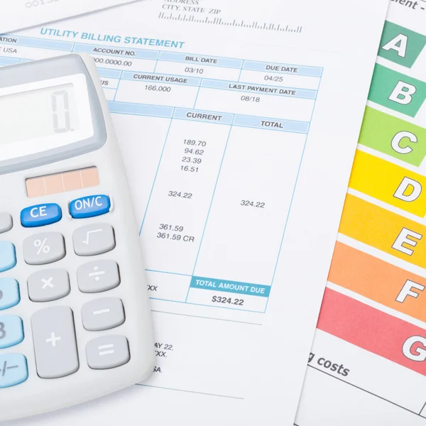 Calculator with utility bill and energy rating chart under it - 1 to 1 ratio — Stock Photo, Image