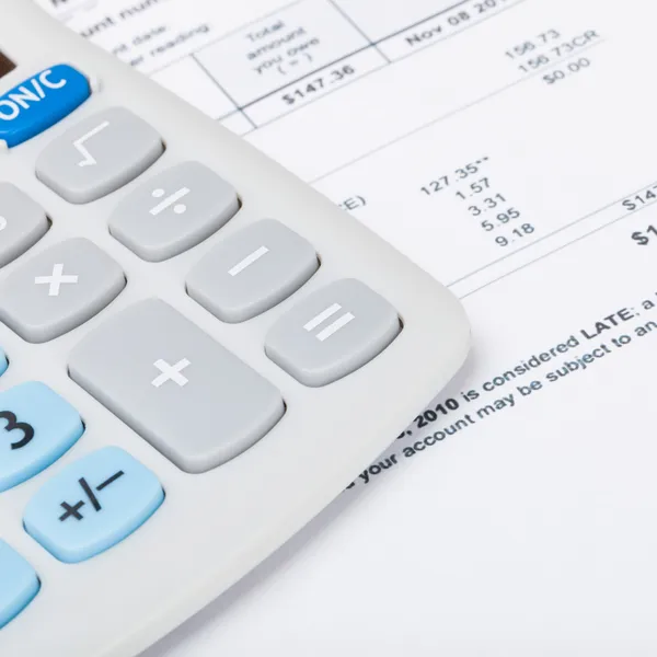 Utility bill with calculator over it - 1 to 1 ratio — Stock Photo, Image