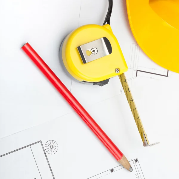 Casque de chantier jaune avec bande de crayon et de mesure sur certains documents - rapport 1 à 1 — Photo