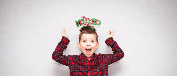 陽気な幼児男の子で新年のフープと赤チェックされたパジャマスーツ彼の手を上げ — ストック写真
