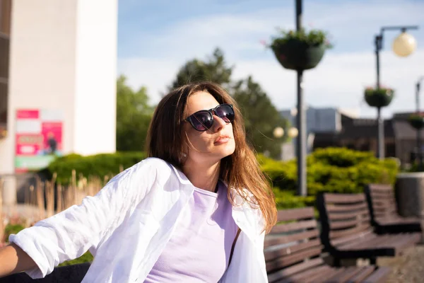 Young Slender Woman Sits Bench Sunglasses White Shirt Sunny Weather — Stockfoto
