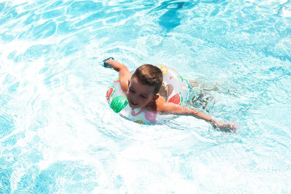 Ein Kleiner Junge Schwimmt Einem Schönen Blauen Pool Einem Aufblasbaren — Stockfoto