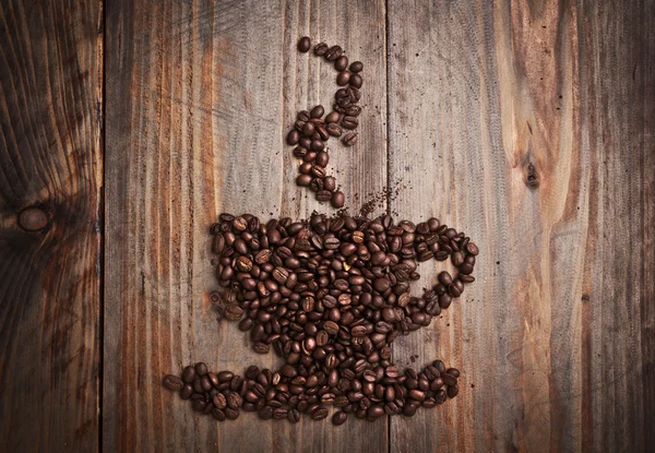 Tasse à café en forme de grains de café sur table en bois — Photo