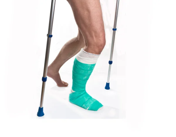 Man with a broken leg with Crutches on a white background — Stock Photo, Image