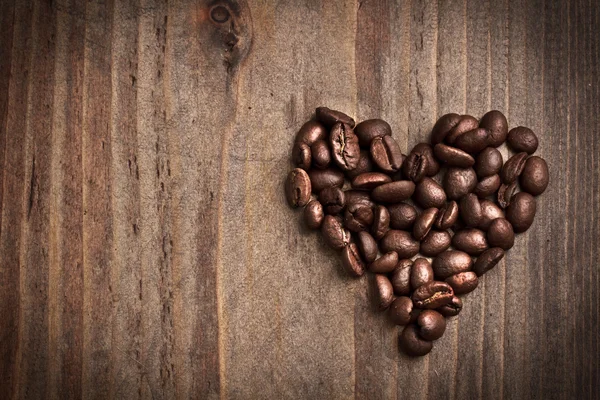 Coeur en forme de grains de café sur table en bois — Photo