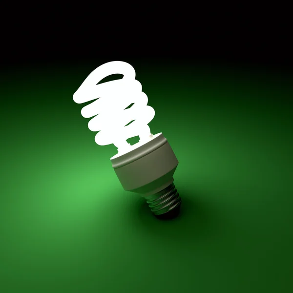 Illuminated light bulb on green background — Stock Photo, Image