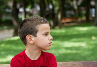 bir parkta bankta üzgün çocuk