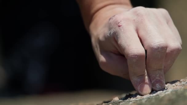 Detailní záběr na prsty horolezce, jak se chytá skalnatého reliéfu — Stock video