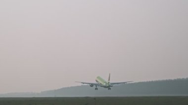 Büyük yeşil bir yolcu uçağı kalkıyor..