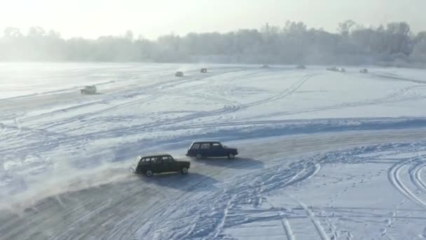 Drone schot van twee raceauto 's glijden op een ijsbaan. Wedstrijden op een bevroren meer. — Stockvideo