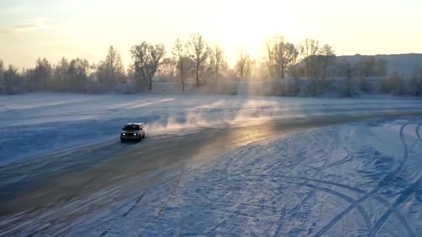 Langzame beweging van een auto drijvend op een winter ijsweg bij zonsondergang. — Stockvideo