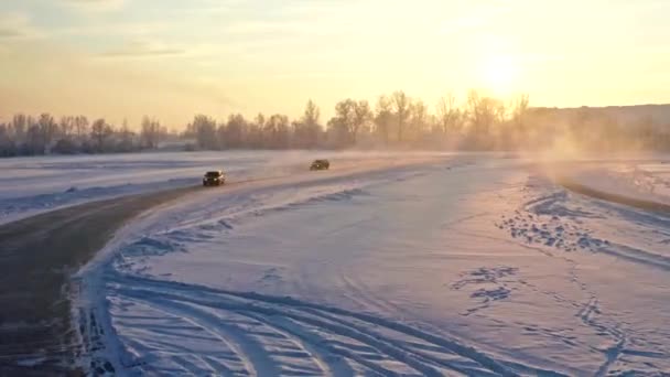 Závodní auta soutěžit na ledové dráze při západu slunce. — Stock video