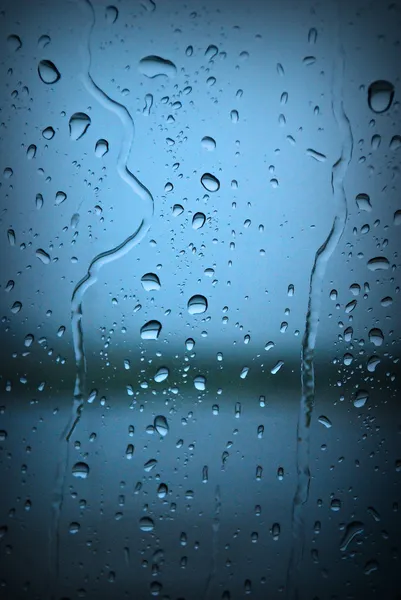 Gotas de lluvia en la ventana azul — Foto de Stock