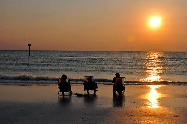 3 personnes au coucher du soleil sur la plage — Photo