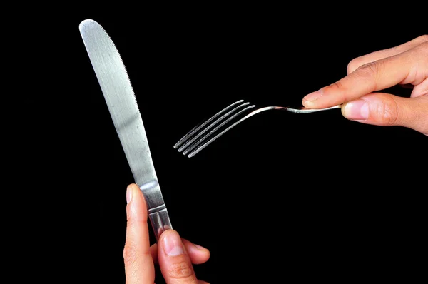 Par de mãos segurando um garfo e uma faca — Fotografia de Stock