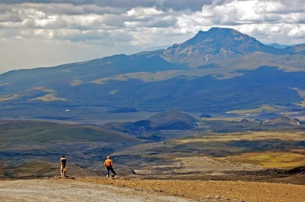 Dos hombres disfrutando de la vista de un valle y el volcán Sincholagua —  Fotos de Stock