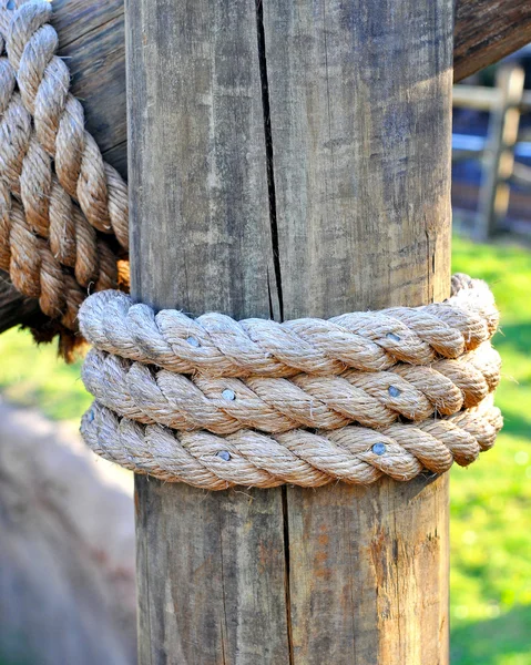 Three layers of rope tied around a wooden log — Stock Photo, Image