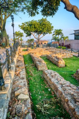 Guayaquil, Ecuador - November, 2013: Old ruins still preserved and protected, at the top of the Saint Ana Hill (Cerro Santa Ana), surrounded by palm trees, at sunset.